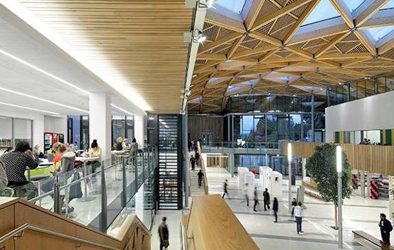 Inside the Exeter Forum, looking towards the student services centre and retail outlets, with the modern design providing a vibrant social environment.