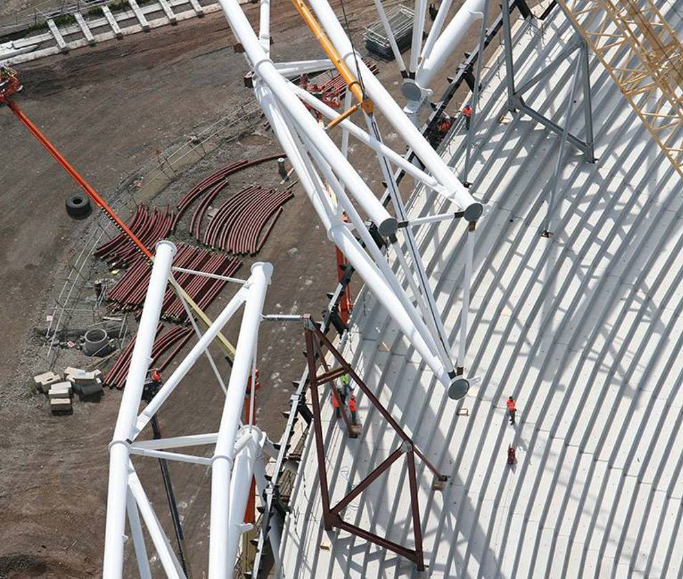 Engineers and construction workers implementing sustainable building practices at the Olympic Stadium