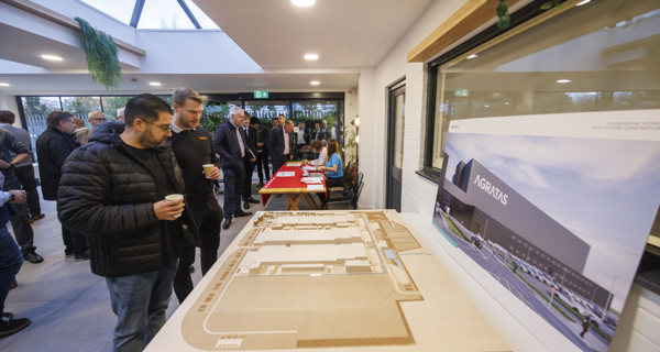 Attendees looking at a table display showcasing a model of the Agratas battery facility