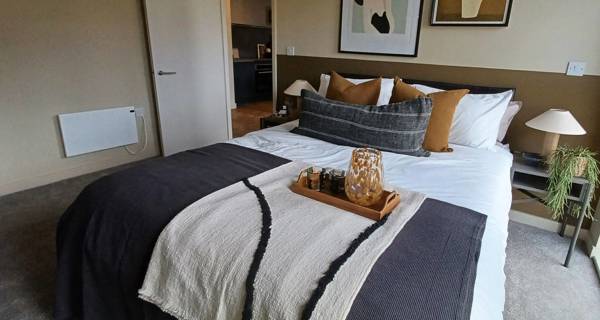 Bedroom in a Tower Works apartment, with modern decor, and ample natural light.