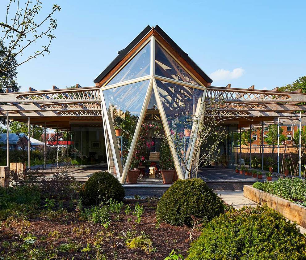 Exterior view of Maggie’s at The Christie in Manchester, a timber and glass pavilion designed by Lord Norman Foster, showcasing its modern architectural design.