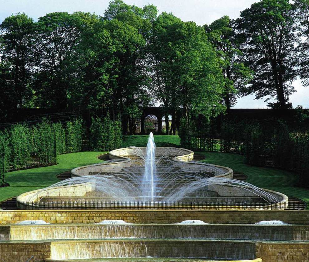  A detailed shot of the fountain's intricate design, with water flowing gracefully over stone tiers.