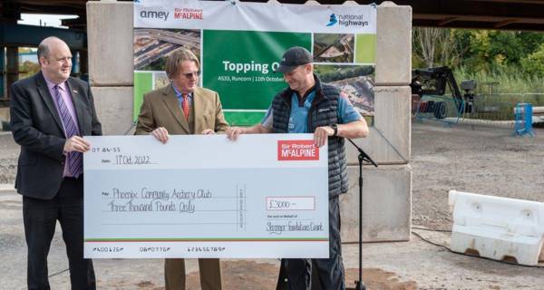 Sir Andrew McAlpine presents a cheque to the Phoenix Community Archery Club