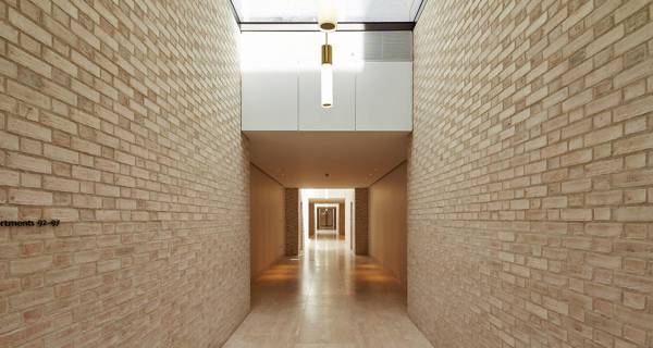 Corridor of De Vere Gardens, featuring marble floors, high ceilings, and modern lighting