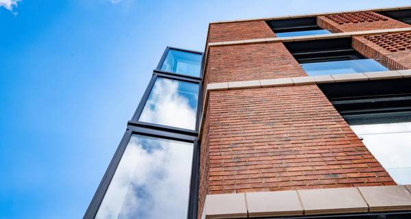 Close-up of traditional brickwork and stone banding on the facade of Mustard Wharf’s residential blocks.