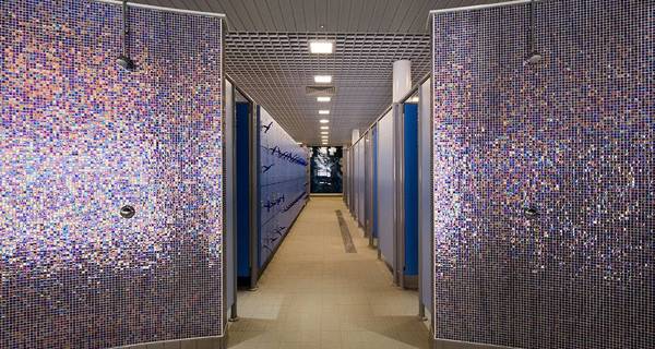 A communal locker room equipped with showers, designed for use by pool visitors.