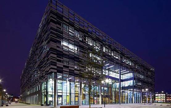 Exterior night shot of the Birley Fields campus, showcasing the building’s solar veil illuminated.