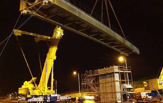 Engineers working on raising and widening a bridge over the M1, part of the infrastructure improvements to accommodate the expanded motorway.