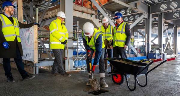 Close-up shot of the concrete being poured as part of the traditional topping-out ceremony