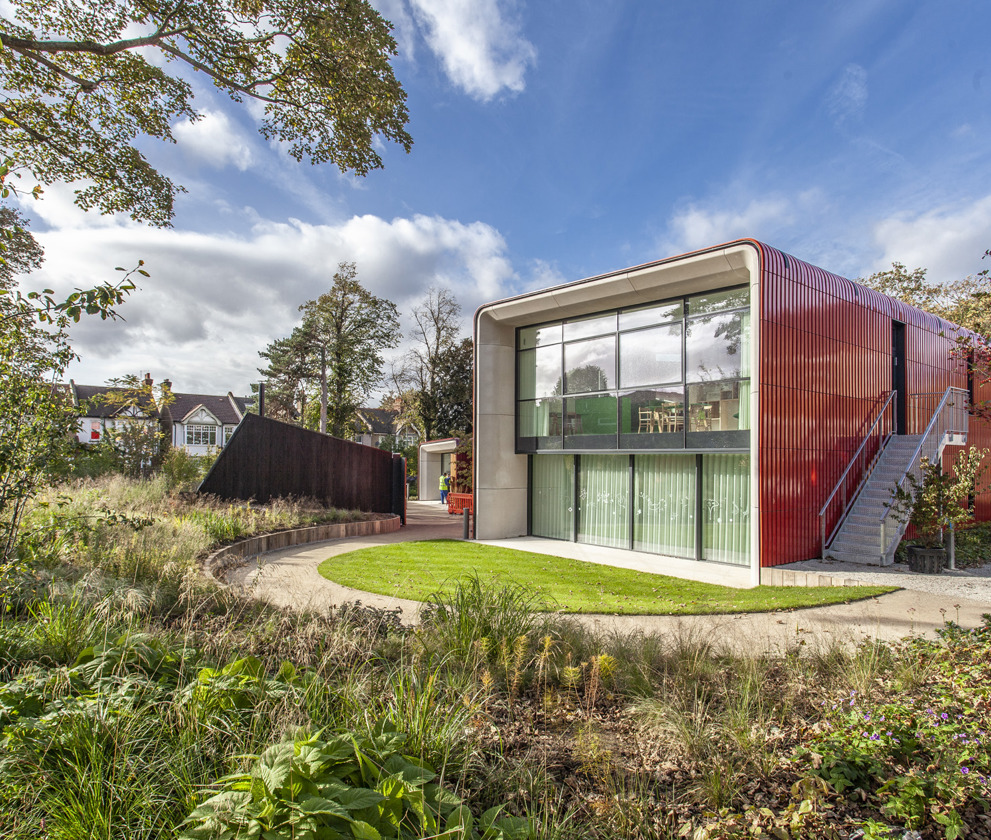 The exterior garden view of Maggie's Royal Marsden, with lush greenery, walking paths.