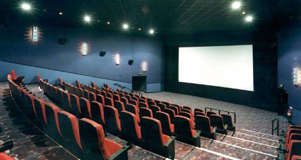 Rows of cinema seats leading up to a large projection screen.