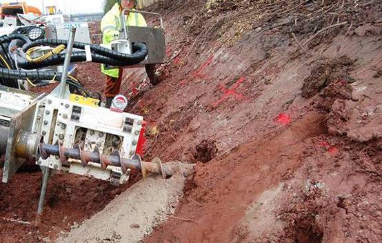 Engineer showcasing sustainable techniques like gabions and soil nailing to reduce retaining wall costs