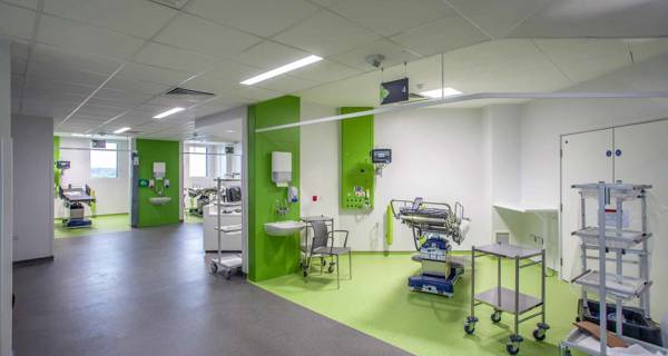 Child-friendly pediatric care area at Chase Farm Hospital, decorated with vibrant colours and equipped with interactive digital tools to comfort young patients.