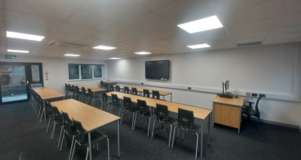 Interior view of a classroom with modern desks and chairs, ready for students.