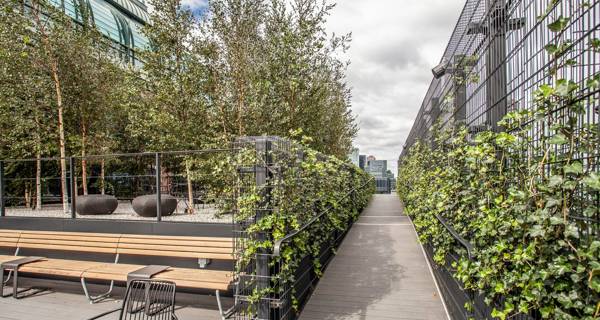 The exterior garden view of 135 Broadgate, with lush greenery, walking paths