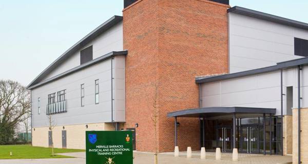 The main entrance to Colchester Garrison, displaying a modern security gatehouse and landscaped approach